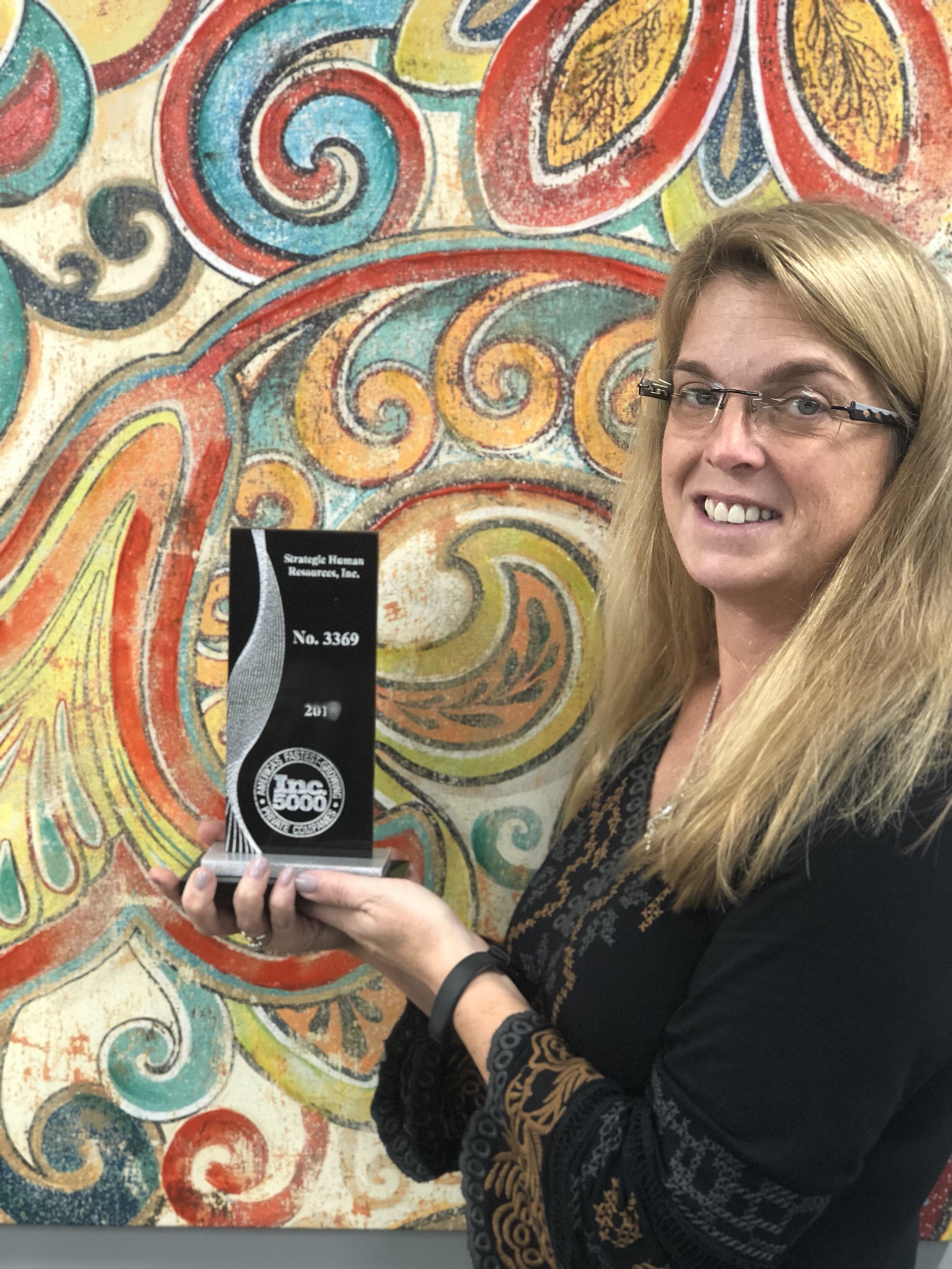 strategic HR inc. president, Robin Throckmorton, holding the Inc 5000 Award recognizing strategic HR inc. as one of the fastest growing companies in America!